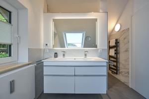 a bathroom with a white sink and a mirror at Ferienwohnung Carpe Diem in Füssen