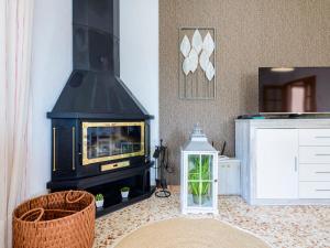 a living room with a wood stove and a microwave at Villa Villa Lolin by Interhome in Vinaròs +16 photos