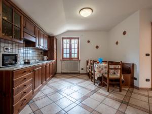 a kitchen with wooden cabinets and a table in it at Apartment Chaouette by Interhome in Sarre