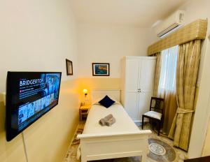 a bedroom with a bed and a flat screen tv at The Maltese Sun in Sliema