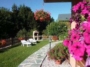 een tuin met roze bloemen en een stenen pad bij Apartment Namasté by Interhome in Les Villards-sur-Thônes