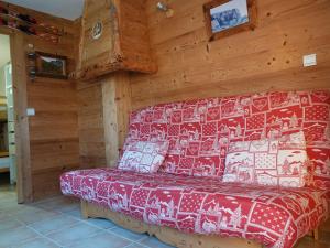 Les Villards-sur-ThônesにあるApartment Namasté by Interhomeのログキャビン内のベッド1台が備わる客室です。