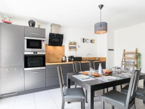 eine Küche mit einem Tisch und Stühlen sowie ein Esszimmer in der Unterkunft Apartment Les Patios de Flore-1 by Interhome in Mimizan-Plage + 25 Fotos