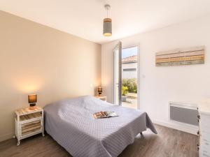 ein weißes Schlafzimmer mit einem Bett und einem Fenster in der Unterkunft Apartment Les Patios de Flore-1 by Interhome in Mimizan-Plage