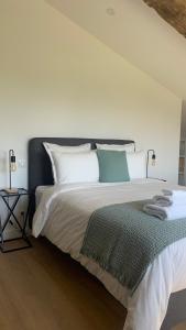 una camera da letto con un grande letto bianco con cuscini bianchi di Maison Divon a Montagne
