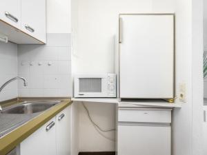 uma cozinha branca com um micro-ondas e um lavatório em Apartment A601 by Interhome em Lahnstein