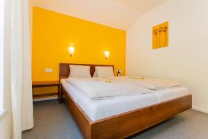una camera da letto con un grande letto con una parete gialla di Apartment Kitz View 14 Top 4 - by Four Seasons Apartments a Kaprun