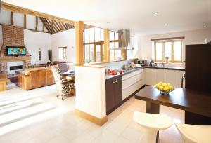 a kitchen and living room with a table and a dining room at Thatch Barn in Lingwood