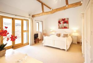 a bedroom with a white bed and a tv at Thatch Barn in Lingwood