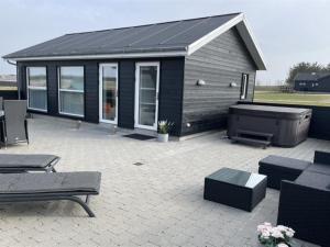 a house with a patio and a grill at Holiday Home Dwerg - 1-5km from the sea in NW Jutland by Interhome in Løkken
