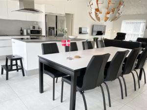 a kitchen and dining room with a table and chairs at Holiday Home Dwerg - 1-5km from the sea in NW Jutland by Interhome in Løkken