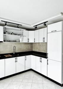 a kitchen with white cabinets and a sink at Magnifique appartement en plein centre ville in Kenitra