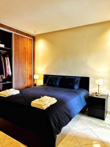 een slaapkamer met een groot bed met blauwe lakens bij Magnifique appartement en plein centre ville in Kenitra