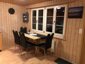 une salle à manger avec une table, des chaises et une horloge dans l'établissement Apartment Lohnerblick by Interhome, à Adelboden