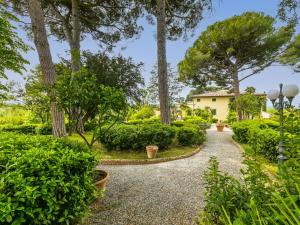 une passerelle traversant un jardin avec des arbres et des buissons dans l'établissement Holiday Home Villa La Guardia Vecchia-1 by Interhome, à Crespina