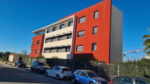 a red and white building with cars parked in front of it at 314 Appartement perpignan Cosy in Perpignan