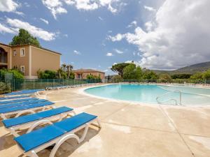 einen Pool mit blauen Liegestühlen in einem Resort in der Unterkunft Apartment Le Domaine de Figuière-2 by Interhome in Sainte-Maxime