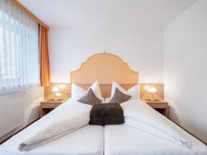 a bedroom with a large white bed with pillows at Apartment Rosa-10 by Interhome in Mayrhofen