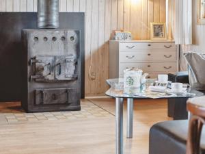 una sala de estar con una estufa antigua y una mesa. en Holiday Home Hristijan - 300m to the inlet in The Liim Fiord by Interhome, en Løgstør
