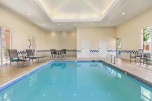 a large swimming pool with chairs and a table at Fairfield Inn & Suites by Marriott Reno Sparks in Sparks