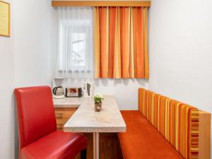 a red chair and a table in a room at Apartment Rosa-9 by Interhome in Mayrhofen