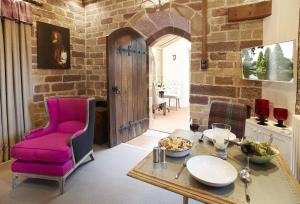 een woonkamer met een tafel en een paarse stoel bij The Knoll Tower in Weston under Lizard