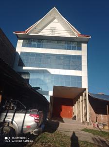 a building with a car parked in front of it at Casa Hospedaje VIRREY in Jauja