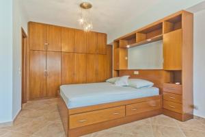 a bedroom with a large bed with wooden cabinets at Crystal Chateau: Μaisonette above the sea in Karpathos Town