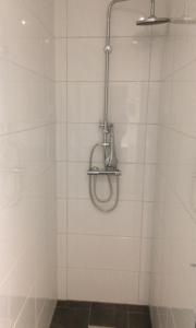 a shower in a bathroom with white tiled walls at Guest House Amsterdam in Amsterdam