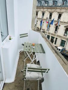 una mesa y sillas en un balcón con banderas en Unirii Downtown Apartment, en Bucarest