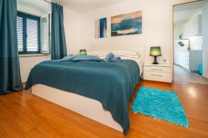 a bedroom with a large bed and a blue rug at Apartment Jelka 1 in Krk