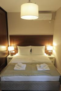 ein Schlafzimmer mit einem Bett mit zwei Handtüchern darauf in der Unterkunft ZARO Apartments in Bitola