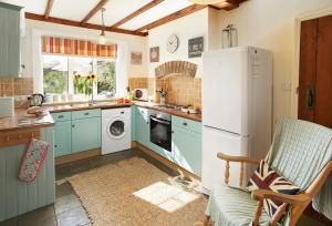 a kitchen with blue cabinets and a white refrigerator at Heather Cottage in Gillamoor