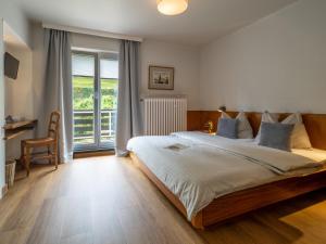 Un dormitorio con una cama grande y una ventana en Hotel Heintz en Vianden