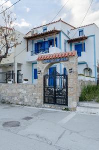 a blue and white house with a gate at Cleopatra Studios in Marathokampos