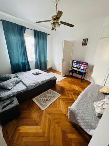 1 dormitorio con 2 camas y ventilador de techo en Unirii Downtown Apartment, en Bucarest