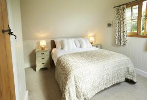 a white bedroom with a bed and a window at The Loft in South Stoke
