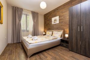 ein Schlafzimmer mit einem Bett und einer Holzwand in der Unterkunft Apartment Obelix / Kapana / Center Private Parking in Plowdiw