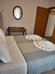 a bed in a bedroom with a mirror on the wall at Roumeliotis house in Karpathos