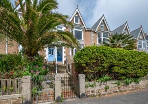 a house with palm trees in front of it at Upper Black Rock in St Ives