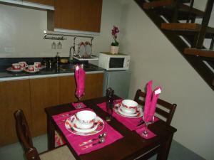 a kitchen with a table with pink napkins and a table sidx sidx at Mondavi II Condo Unit 306 in Silang
