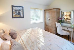 a bedroom with a bed and a desk with a mirror at The Cwtch in Pencoed
