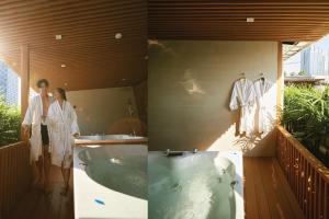 two people standing in a bathroom with a bath tub at Arck Hotel in Bangkok