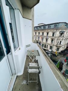 un balcón con una mesa y un banco en un edificio en Unirii Downtown Apartment, en Bucarest
