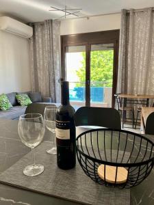 カリテア・ハルキディキにあるEmiliya Mのワイングラス2杯付きのテーブルに座ったワイン1本