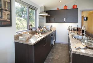 a kitchen with black cabinets and a sink and a window at High Bridge Haven in Soutergate