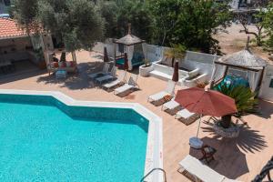 an overhead view of a swimming pool with chairs and an umbrella at Bronze Hotel in Oludeniz