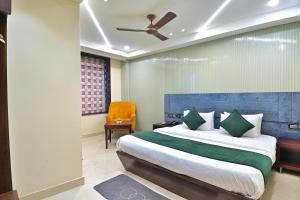 a bedroom with a large bed with a blue headboard at Hotel Vanson Delite - New Delhi Railway Station in New Delhi