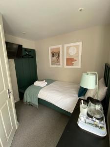 a small bedroom with a bed and a table with a lamp at Brayford House in Lincoln