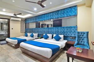 a bedroom with two beds and a blue wall at Hotel Vanson Delite - New Delhi Railway Station in New Delhi
